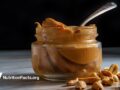 glass jar of peanut butter on dark background
