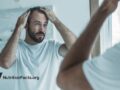 middle aged man with hair loss looking in mirror
