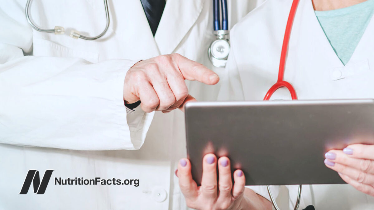 two doctors discussing medical report on a tablet