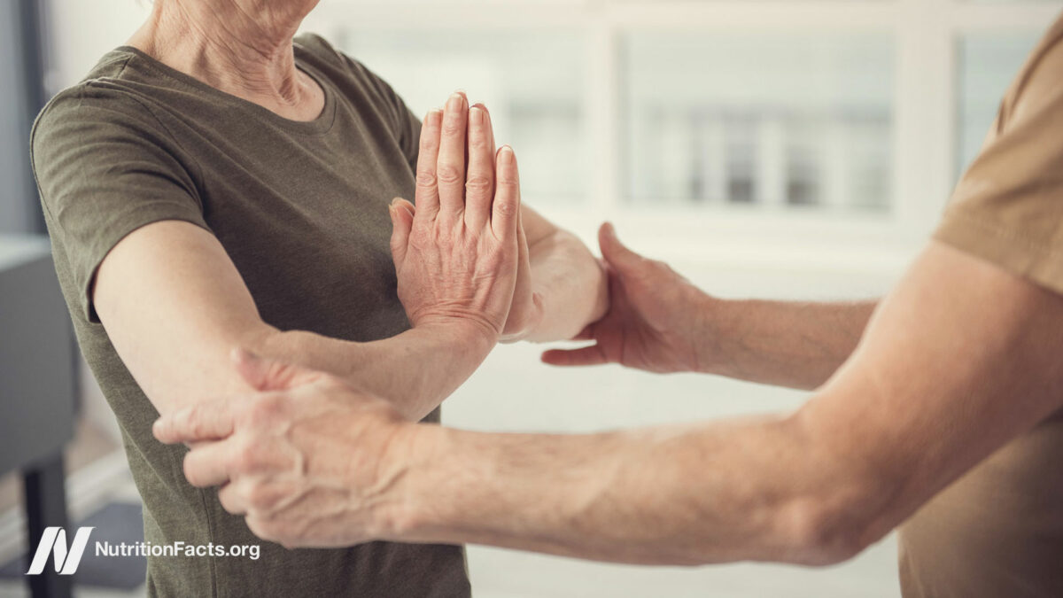 Two people helping each other with yoga poses