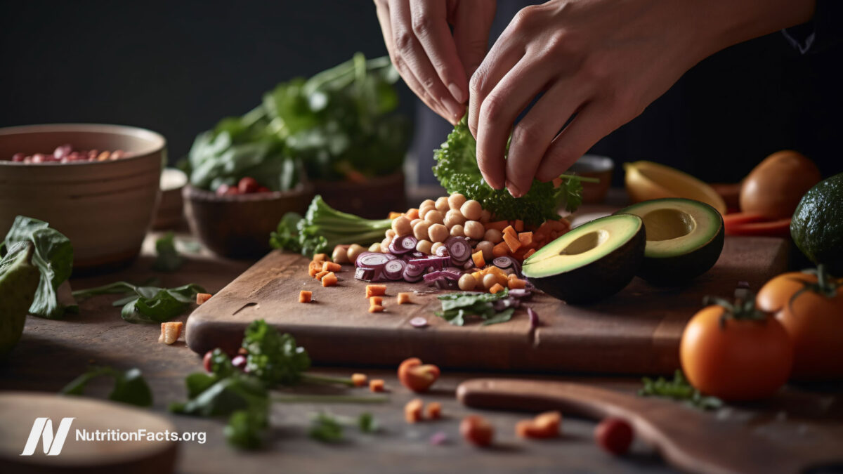 Close up of person’s hands preparing meal with fresh veggies
