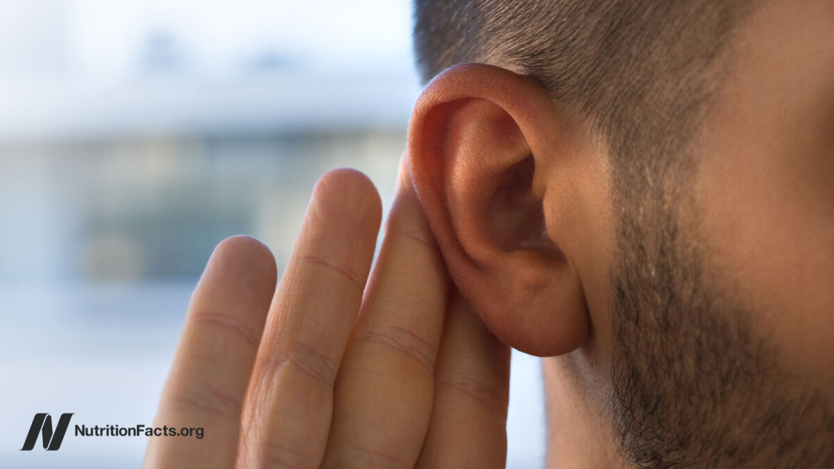 Young man with hearing problems, hearing loss or hard of hearing