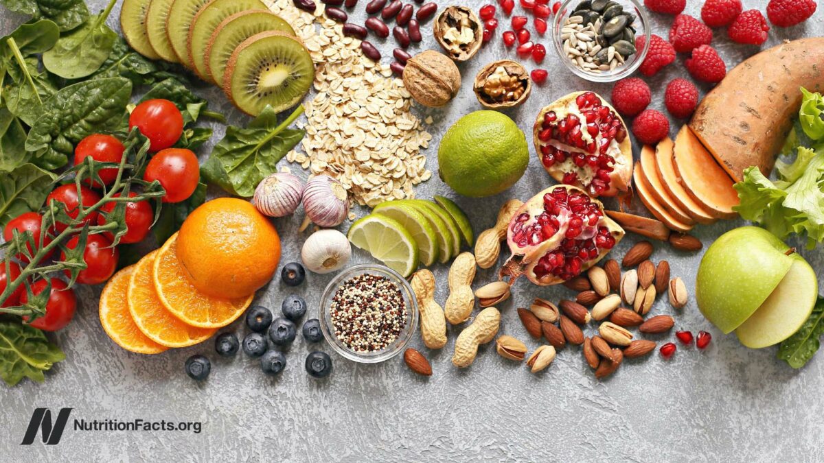 Assortment of veggies, fruit, green leaves, grains and cereals, seeds and nuts