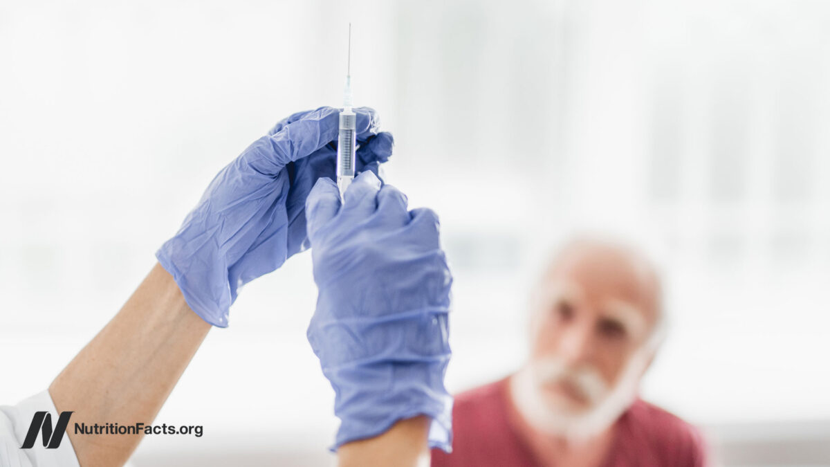 Close up of female medic preparing to make injection. Old man on blurred background