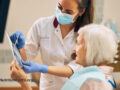 Dental assistant showing results to patient