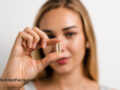 young woman holding a supplement pill