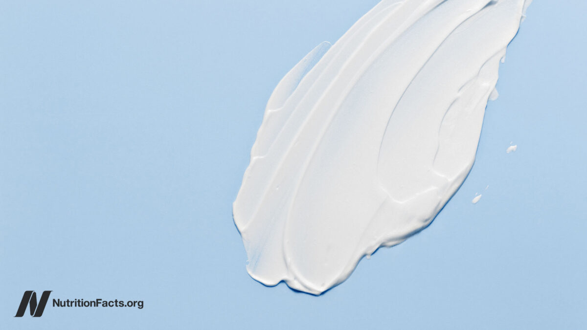 White cosmetic cream lotion moisturizer strokes on pastel blue