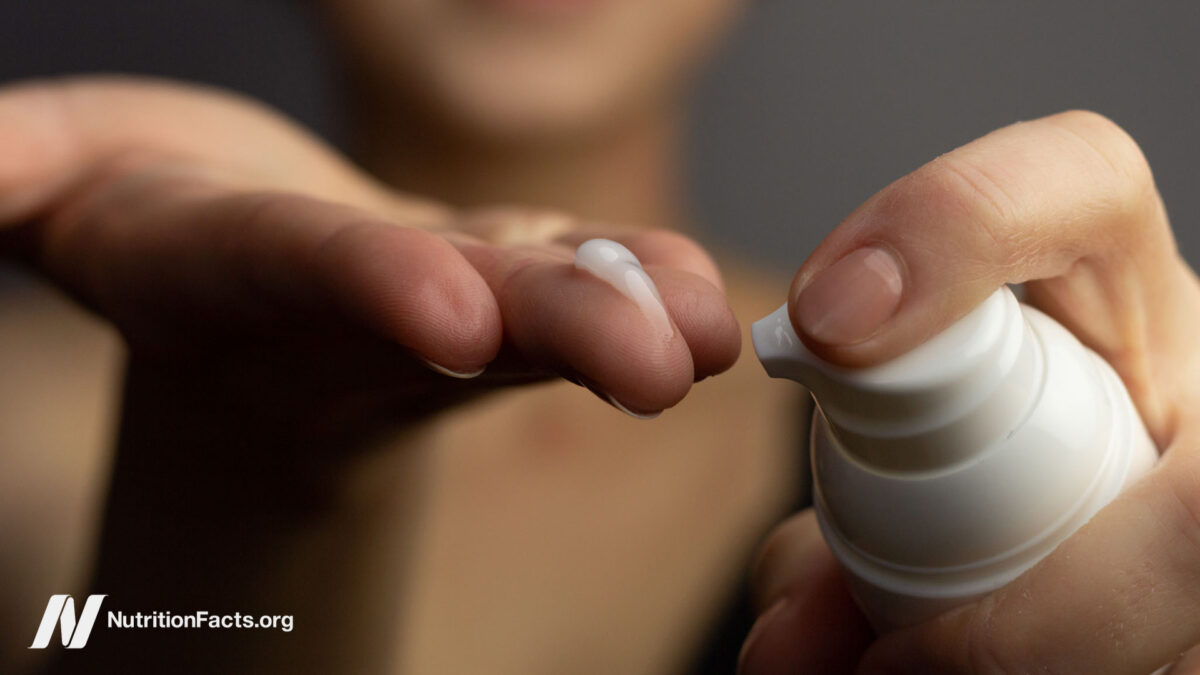 Closeup of a young woman applying prescription retinoid to her face