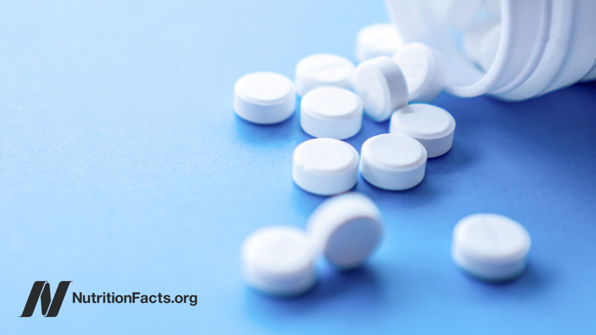 White tablets from a bottle onto blue surface